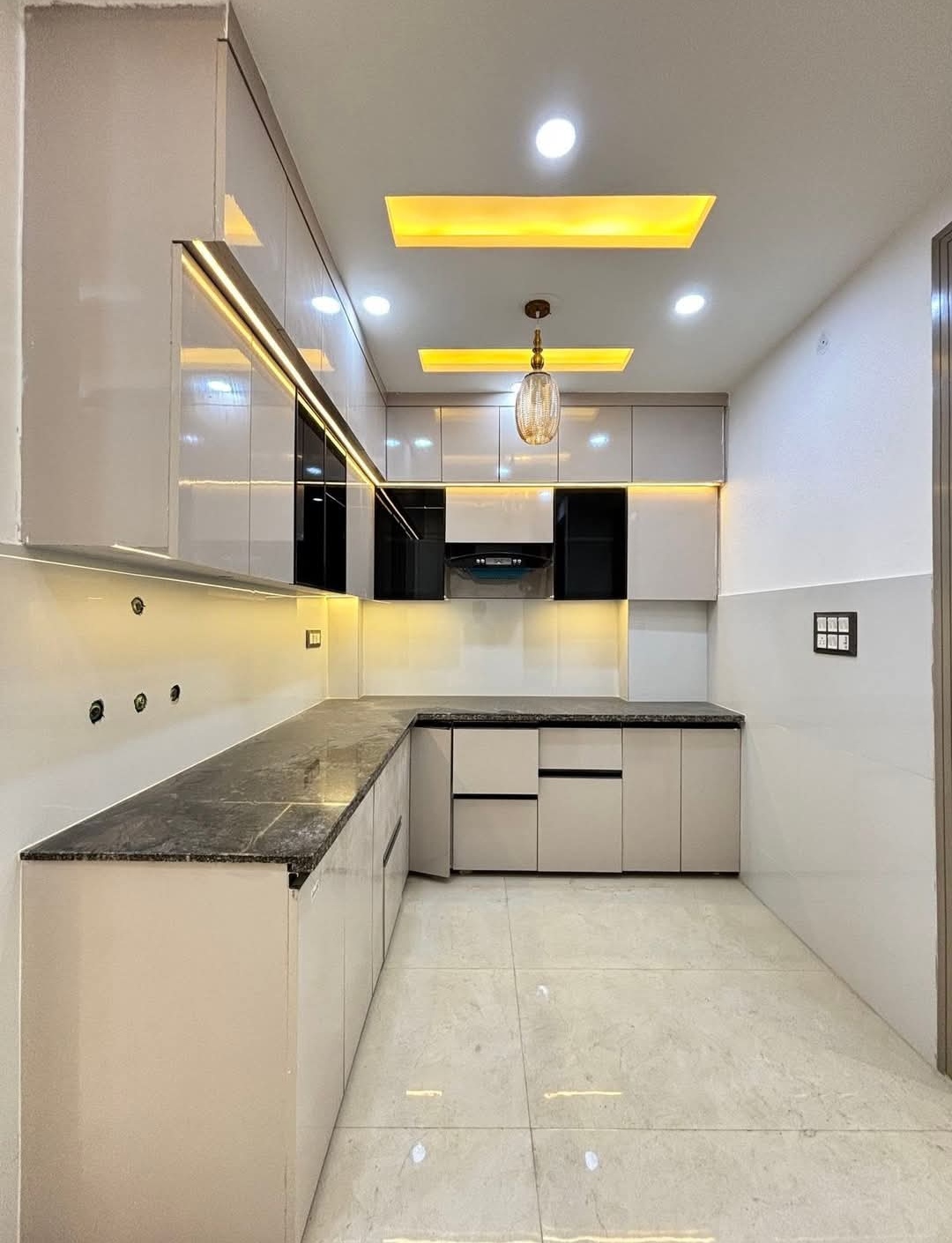 L-shaped space saving kitchen design completed by Etminaan Services in Karachi for small homes.