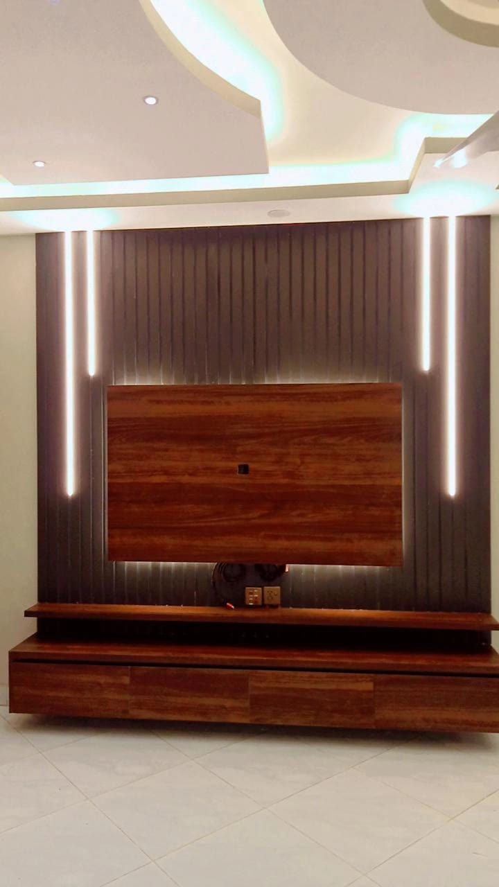 Etminaan Services completed a modern media wall with premium tactile sheet finish in brown wood texture and grey panels in Karachi.