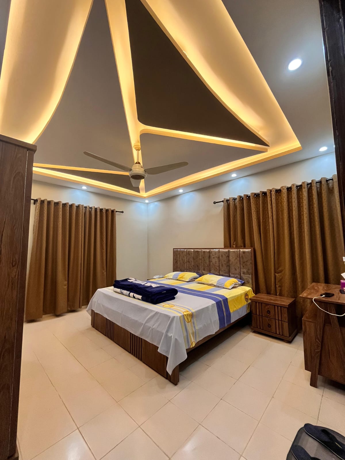 Modern bedroom interior with false ceiling and premium finishing by Etminaan Services.